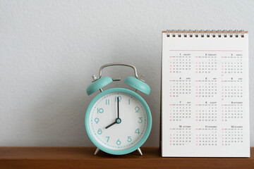 close up of calendar and alarm clock on the bedroom background, morning lifestyle concept