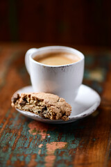 Cantuccini (Italian cookie) and a cup of coffee on dark wooden background. Close up.	