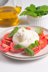 Delicious Italian caprese salad with sliced mozzarella, tomatoes, basil, and bread on background. 