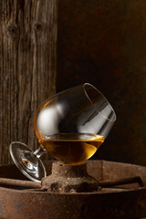 Cognac in snifter on old rusty wheel.