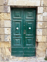 Old wooden green door in stone building