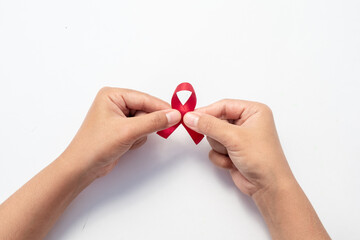 Female hand hold red ribbon, HIV awareness concept, world AIDS day, world cancer day isolated white background.