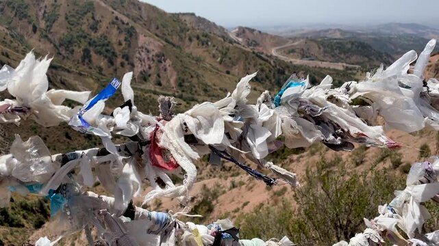 ribbons of desires tied to fancy against backdrop of a mountain and blue sky on Chimgan mountain, Uzbekistan