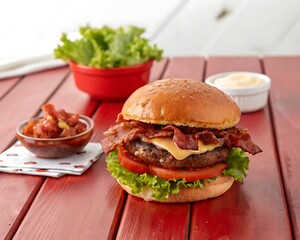 Bacon burger with beef patty on red wooden table