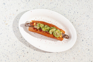Portion of gourmet american hotdog with green sauce