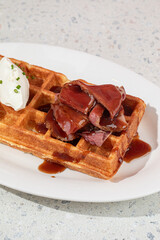 Portion of fresh waffle with beef brisket and cream cheese