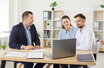 Wife and husband engages in a discussion with a consultant during a meeting in an office, focusing...