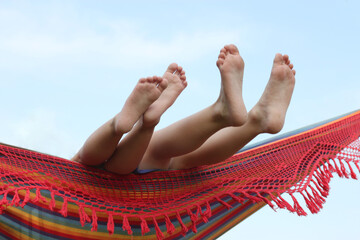 Close-up of two Children's bare feet hanging over the edge of a hammock