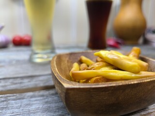 delicious pieces of Chechil cheese on a wooden plate, glasses of beer in the background