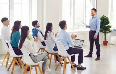 Group of business people applauding during a team meeting or presentation in the office, celebrating a successful work. Spirit of teamwork, collaboration, and achievement in a professional setting.