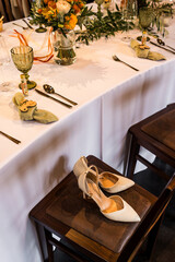 Brautschuhe stehen in einer Hochzeitslocation auf einem Stuhl