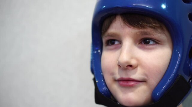 boy in taekwondo helmet with slight smile on face. close-up portrait