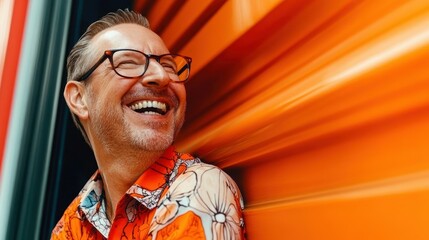 A man wearing glasses and a floral shirt is smiling and laughing. Concept of happiness and joy