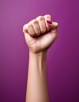 Woman showing fist on purple background for women's day celebration