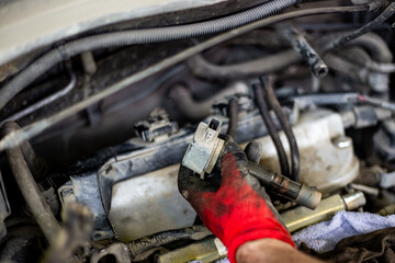 Car repair. Installing a conductor on a spark plug