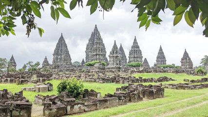 Straight angle view. the Prambanan Temple, Central Java, Indonesia with Scattered solid masonry and greeny leaves as front ground