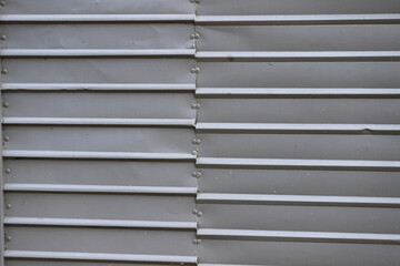 
Surface background of gray metal panels with industrial texture and visible rivets.