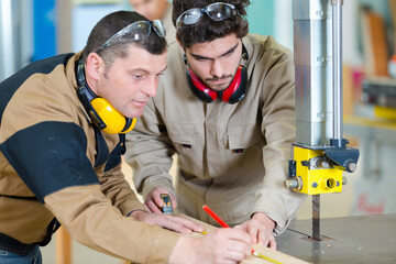 portrait of carpenter training younger man