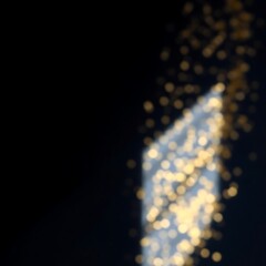 Abstract blurred golden light streaks on black background.