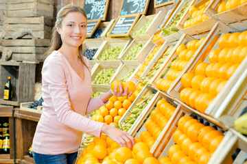 Woman picking out some oranges at the supermarket