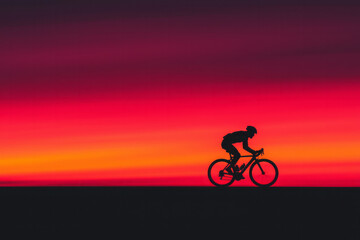 Fototapeta premium A cyclistâ€™s silhouette riding against the backdrop of a dramatic sunset, symbolizing strength and perseverance,