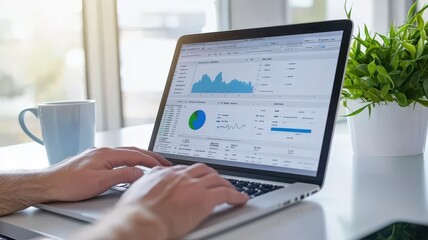 Hands typing on a laptop displaying data charts and graphs, symbolizing business analysis, marketing, or financial performance tracking.