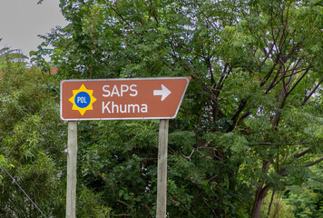 Road sign reading SAPS Khuma with trees in the background. Khuma Police station is close to the mining town of Stilfontein in the North West Province of South Africa. 