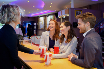 people buying food at a cinema snack bar