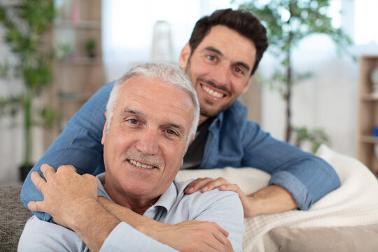 excited man sits on couch spend time with elderly father