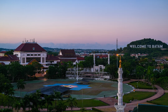 Batam skyline with "Welcome to Batam" text. Cityscape from a window. Batam, a bustling industrial hub, is the largest city in the Riau Islands, known for its vibrant urban landscape.