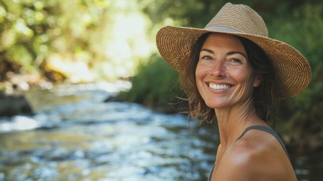 A woman wearing a straw hat is smiling at the camera