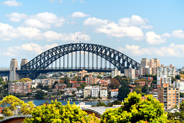 Sydney Harbour Bridge among Sydney North residential buildings in the background viewed from Bradleys Head on a day