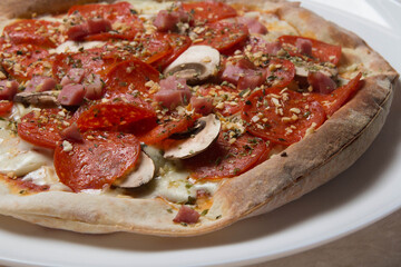 Pizza com queijo mzarella e vários sabores e condimentos, feita de massa fina, farinha