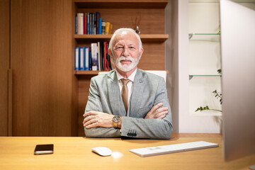 Portrait of caucasian bearded businessman sitting in his luxury office.