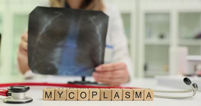 Word Mycoplasma of blocks and medic analyzing chest X-ray in clinic. Lungs infection diagnostic with imaging in clinical healthcare setting