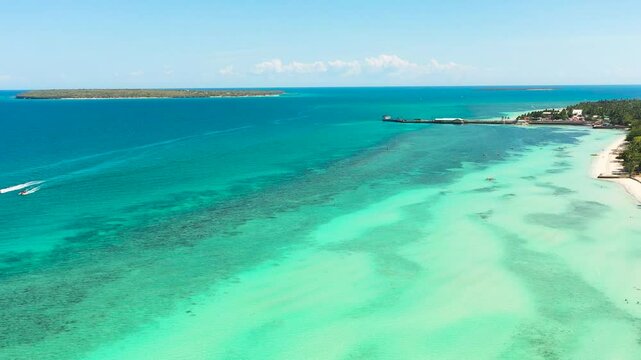 Drone view of boats running over the blue sea. Beaches with white sand and coconut trees in Bantayan Island. Cebu, Philippines.