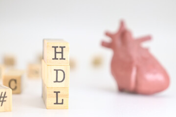 High-density lipoprotein acronym. HDL written on wooden cubes isolated with a heart on white background. Concept of cholesterol 