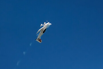 Stunt aerobatic plane inverted flying performing stunts in blue sky. Concept of speed, difficulty,...
