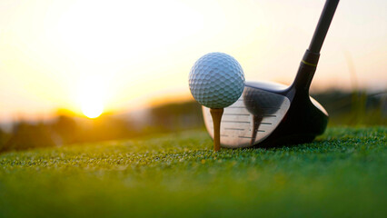 Golf clubs and balls on a green lawn in a beautiful golf course with morning sunshine.
