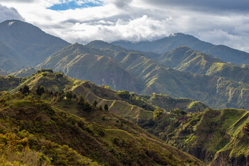 Tierradentro, Inza, Cauca, Colombia.  Beautiful landscape of the Andes Mountains. Valley, mountain range. Pine trees in the foreground. Cloudy sky.