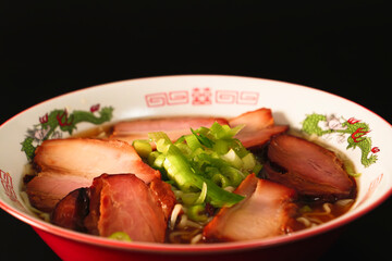 Ramen noodles with lots of meat and green onions, red bowls, steam