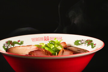 Ramen noodles with lots of meat and green onions, red bowls, steam