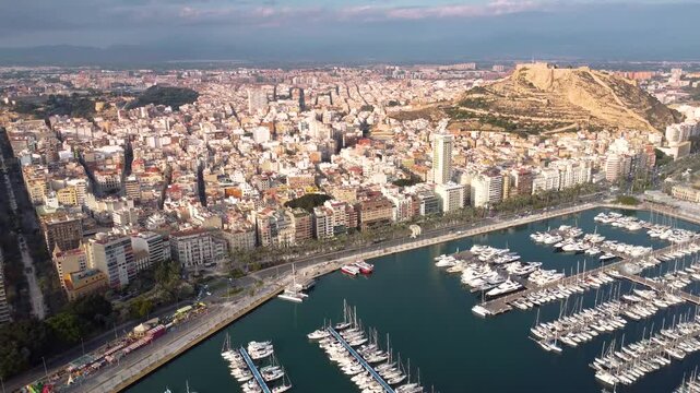 Spectacular aerial view of Alicante city. Panoramic view of all historic center. Promenade and port of Alicante. Castle of Santa B&aacute;rbara on top of the hill. Drone going backwards.   Travel destination