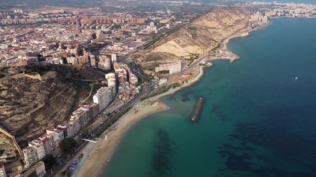 Cinematic aerial view of Alicante city. Famous travel destination in Spain. View of Castle of Santa B&aacute;rbara on top of the hill. Sunset point. promenade of Alicante and Postiguet Beach.