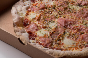 Pizza na caixa de papel&atilde;o com queijo mozarela e v&aacute;rios sabores e condimentos, feita de massa fina, farinha