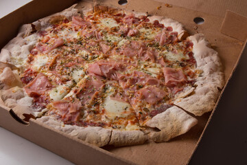 Pizza na caixa de papel&atilde;o com queijo mozarela e v&aacute;rios sabores e condimentos, feita de massa fina, farinha