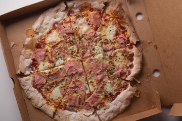 Pizza na caixa de papel&atilde;o com queijo mozarela e v&aacute;rios sabores e condimentos, feita de massa fina, farinha