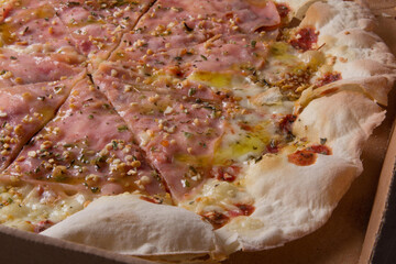 Pizza na caixa de papel&atilde;o com queijo mozarela e v&aacute;rios sabores e condimentos, feita de massa fina, farinha