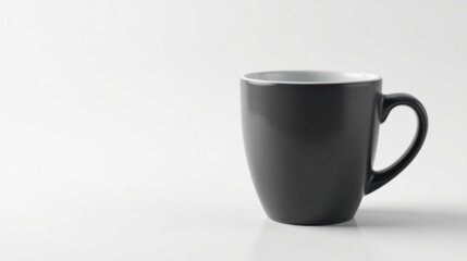 Fototapeta premium A simple dark grey ceramic mug with a white interior sits on a pristine white surface, ready for a beverage