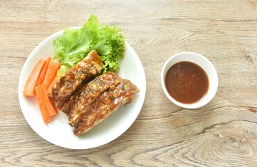 grilled pork rib with carrot and lettuce on plate dipping barbecue sauce cup